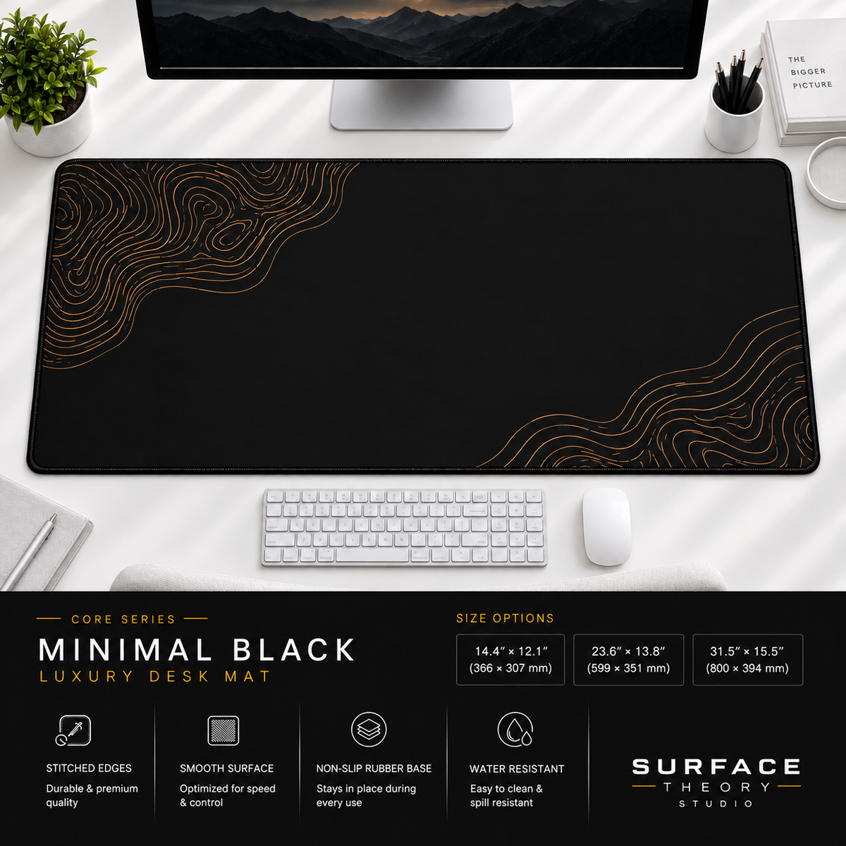 Minimal Black desk mat beneath a monitor on a bright desk with a white keyboard and mouse.