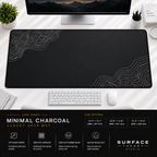 Minimal Charcoal desk mat beneath a monitor on a bright desk with a white keyboard and mouse.