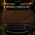 Minimal Chocolate desk mat with gold-toned contour lines on chocolate brown, shown in a warm, dark desk setup.