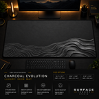 Charcoal Evolution desk mat in a dark workstation with warm monitor lighting.