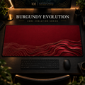 Burgundy Evolution desk mat, burgundy with gold-toned contours widening into layered curves, in a warm, dark workspace.