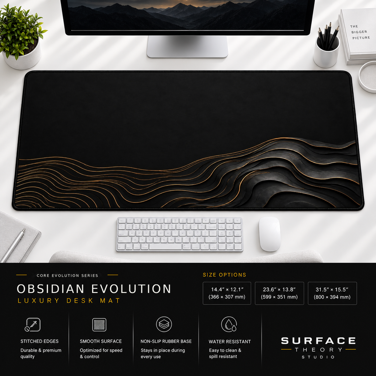 Obsidian Evolution desk mat beneath a monitor on a bright desk with a white keyboard and mouse.