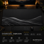 Charcoal Horizon desk mat in a dark workstation with warm monitor lighting.