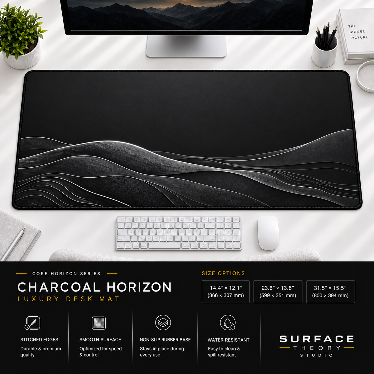 Charcoal Horizon desk mat beneath a monitor on a bright desk with a white keyboard and mouse.