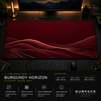 Burgundy Horizon desk mat in a dark workstation with warm monitor lighting.