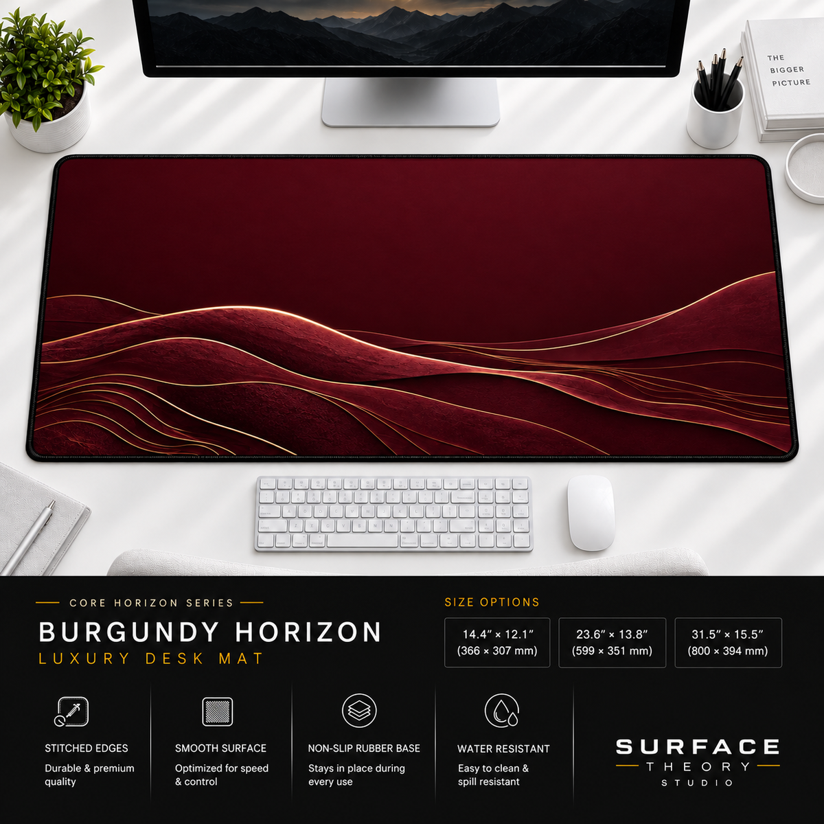 Burgundy Horizon desk mat beneath a monitor on a bright desk with a white keyboard and mouse.