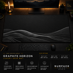 Graphite Horizon desk mat in a dark workstation with warm monitor lighting.