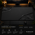 Charcoal Cutaway desk mat in a dark workstation with warm monitor lighting.