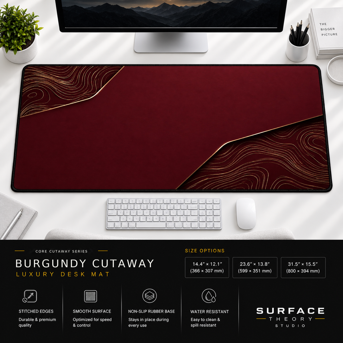 Burgundy Cutaway desk mat beneath a monitor on a bright desk with a white keyboard and mouse.