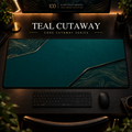 Teal Cutaway desk mat, deep teal with champagne-toned contours in opposing corners, in a warm, dark workspace.