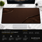 Espresso Cutaway desk mat beneath a monitor on a bright desk with a white keyboard and mouse.