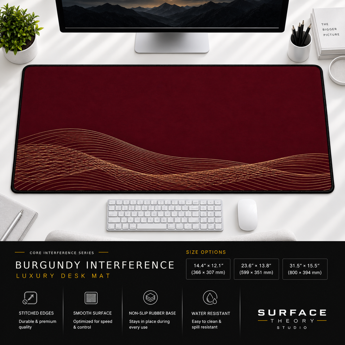 Burgundy Interference desk mat beneath a monitor on a bright desk with a white keyboard and mouse.