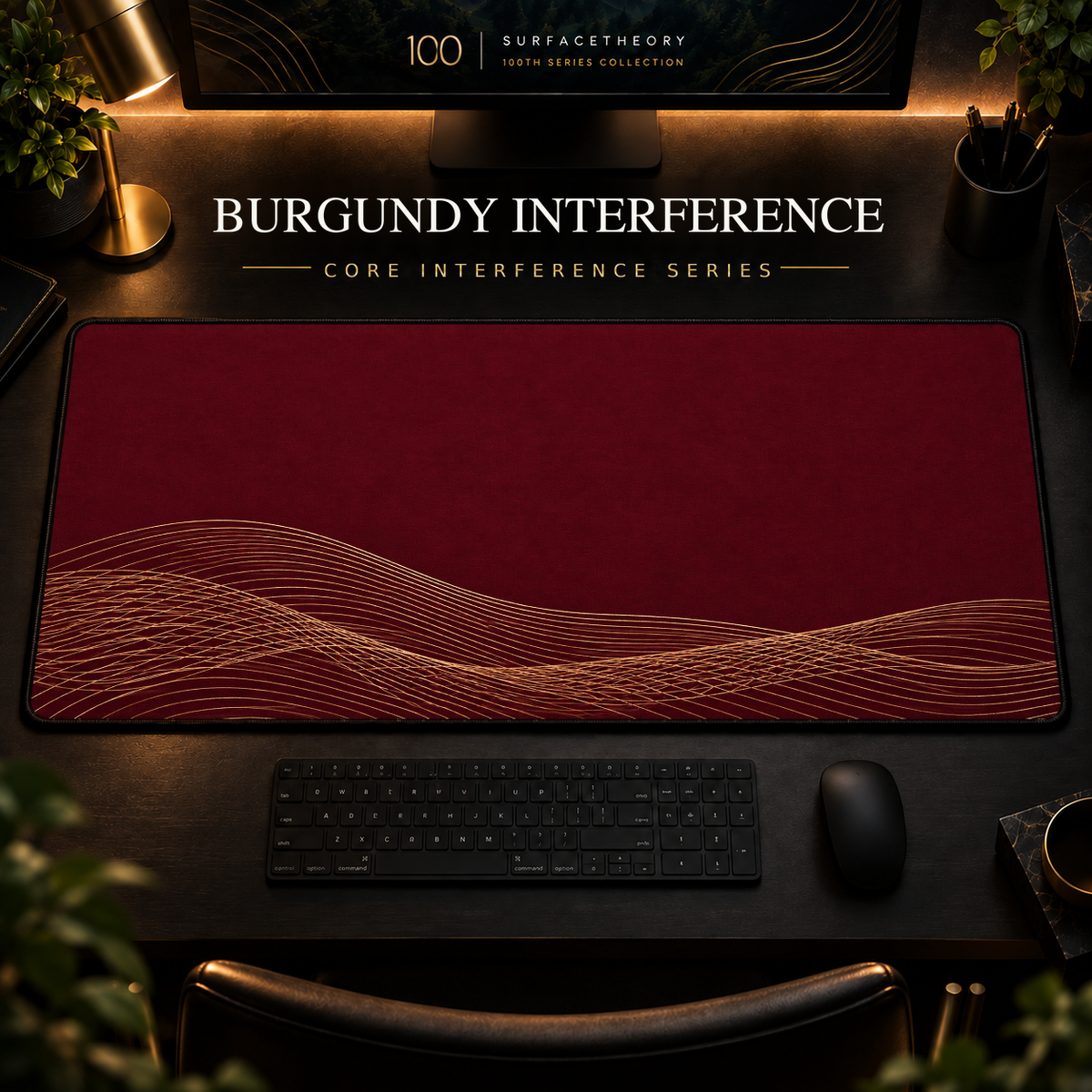 Burgundy Interference desk mat, burgundy with overlapping gold-toned curves along the lower edge, in a warm, dark workspace.