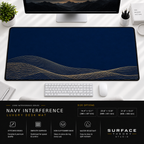 Navy Interference desk mat beneath a monitor on a bright desk with a white keyboard and mouse.