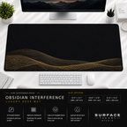 Obsidian Interference desk mat beneath a monitor on a bright desk with a white keyboard and mouse.