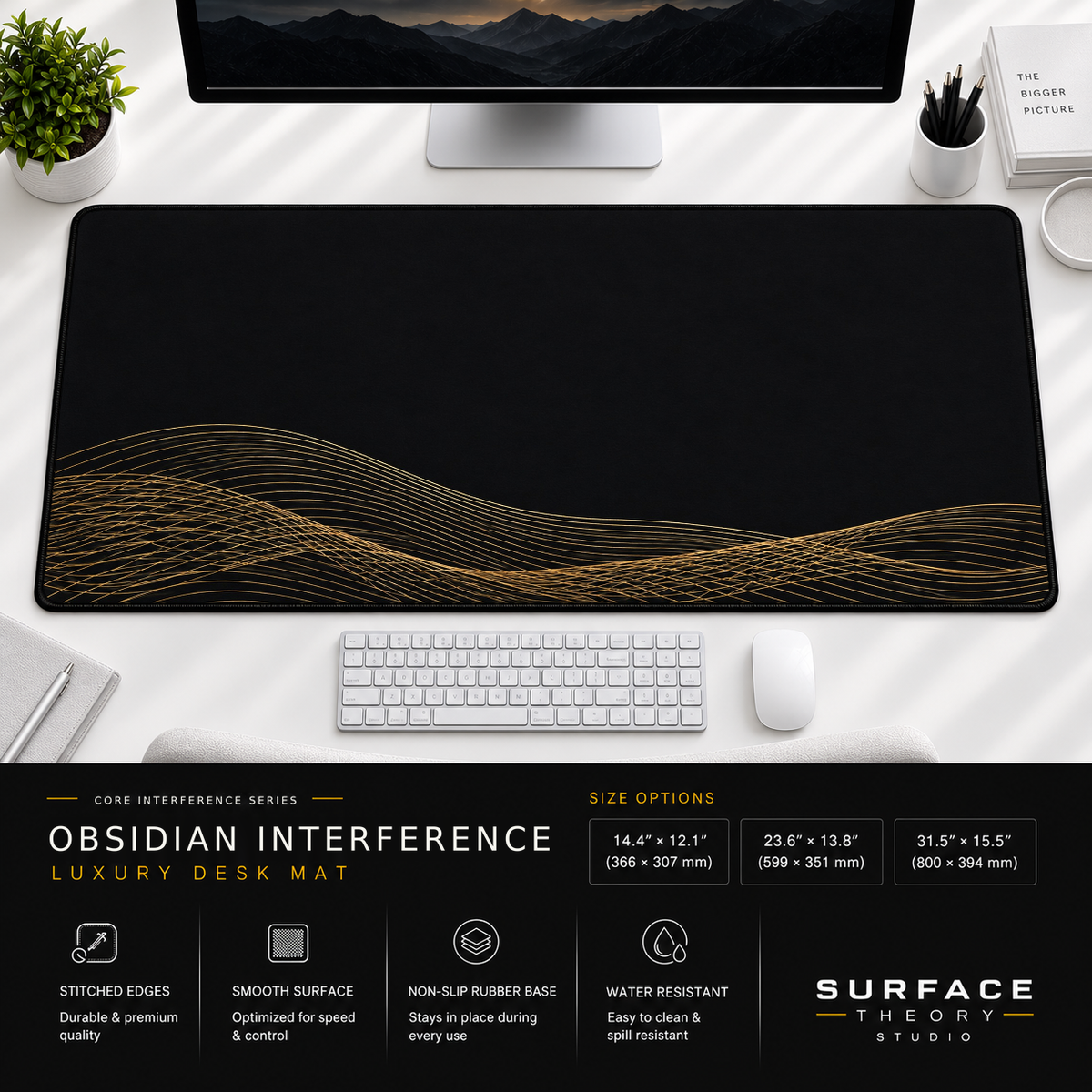 Obsidian Interference desk mat beneath a monitor on a bright desk with a white keyboard and mouse.