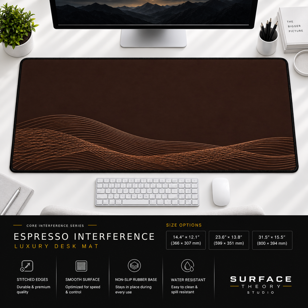 Espresso Interference desk mat beneath a monitor on a bright desk with a white keyboard and mouse.