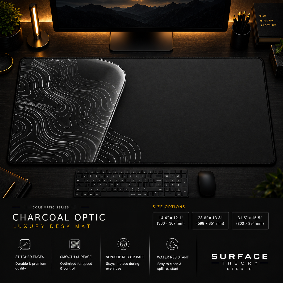 Charcoal Optic desk mat in a dark workstation with warm monitor lighting.