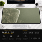 Sage Optic desk mat beneath a monitor on a bright desk with a white keyboard and mouse.