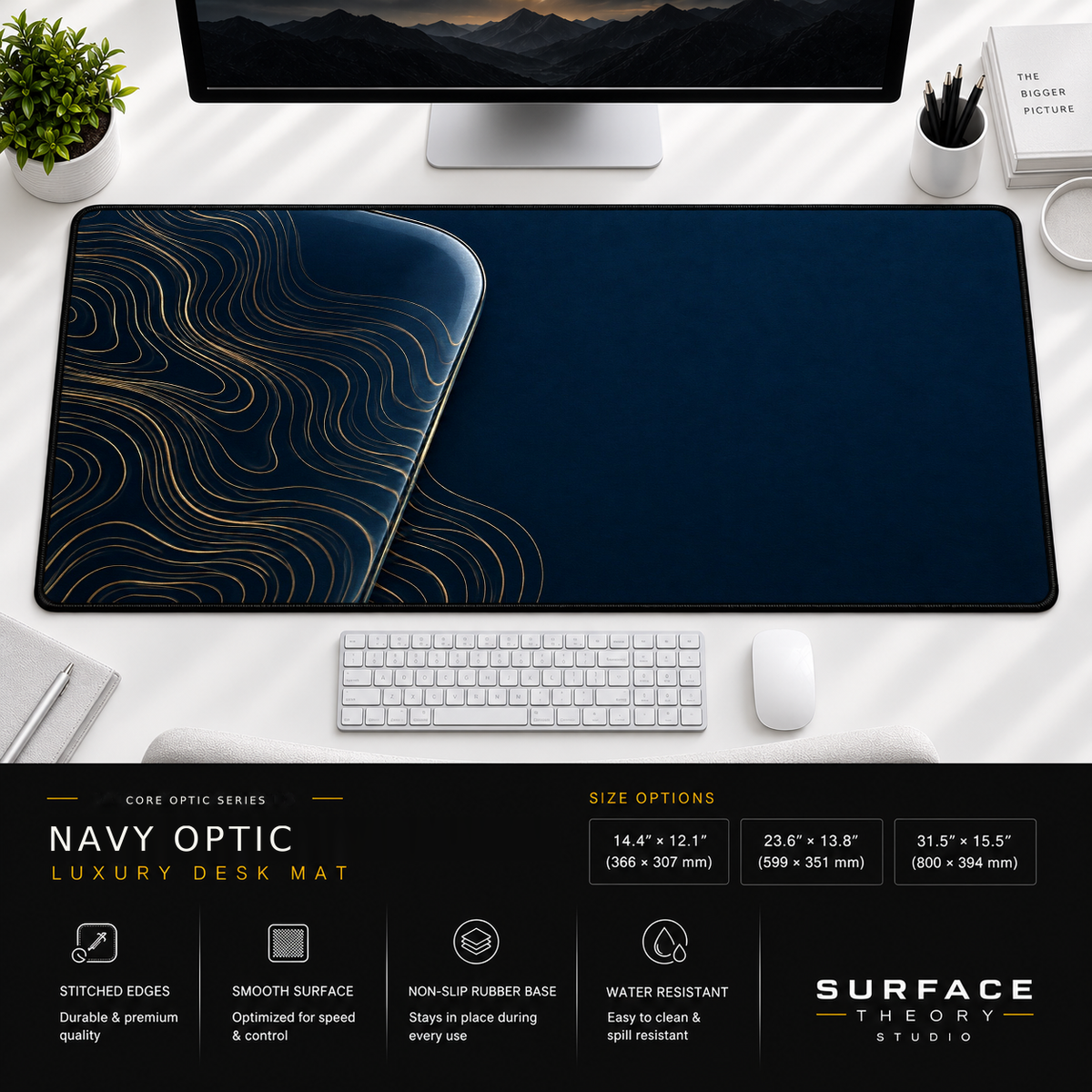 Navy Optic desk mat beneath a monitor on a bright desk with a white keyboard and mouse.
