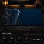 Navy Optic desk mat in a dark workstation with warm monitor lighting.