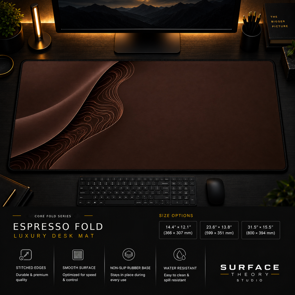 Espresso Fold desk mat in a dark workstation with warm monitor lighting.
