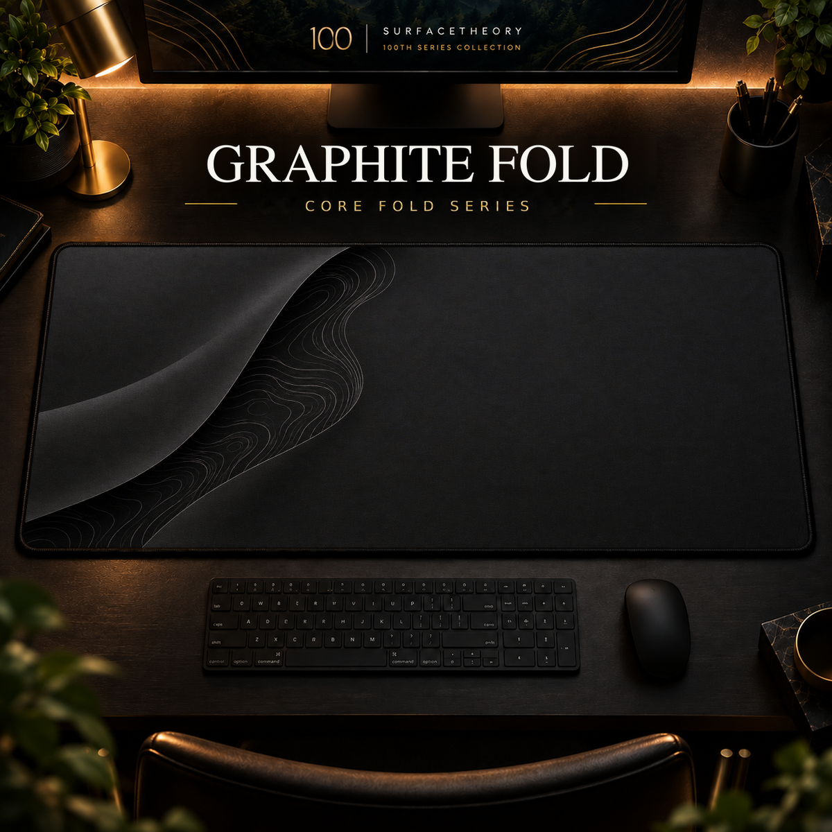 Graphite Fold desk mat with a sweeping curve and fine contours along the left in a warm, dark workspace.