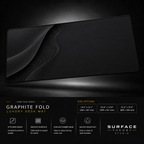 Graphite Fold desk mat floating against a dark studio background.