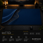 Navy Fold desk mat in a dark workstation with warm monitor lighting.