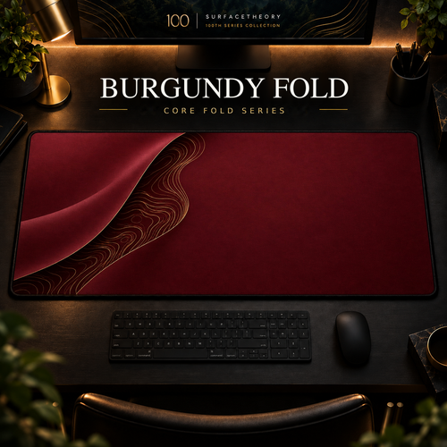 Burgundy Fold desk mat with a sweeping curve and fine contours along the left in a warm, dark workspace.