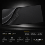 Charcoal Fold desk mat floating against a dark studio background.