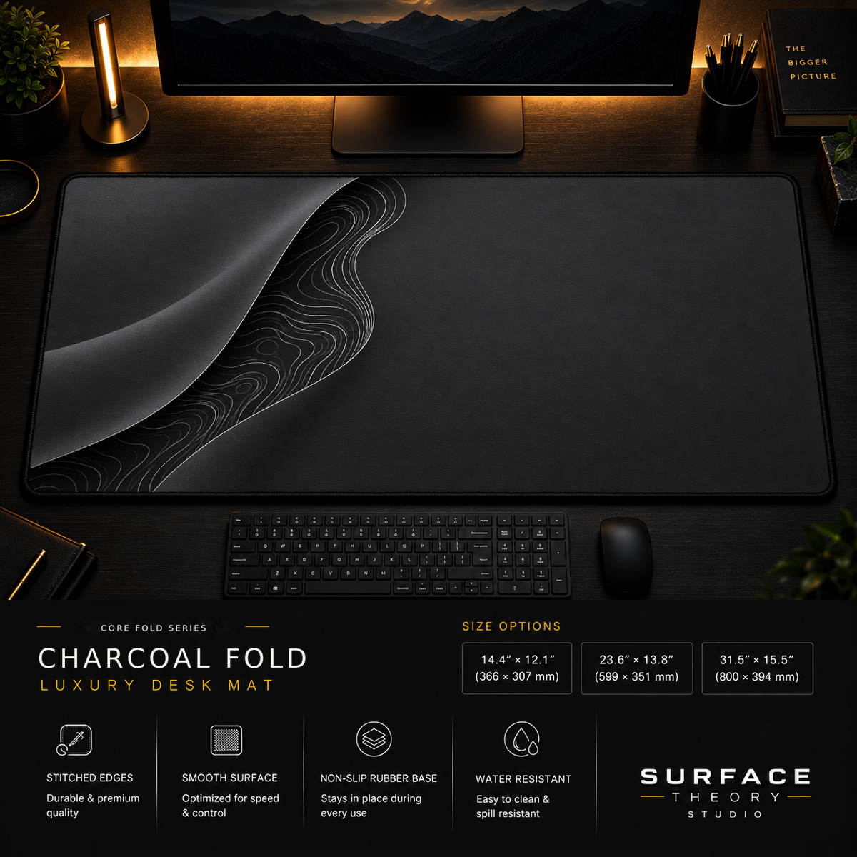 Charcoal Fold desk mat in a dark workstation with warm monitor lighting.