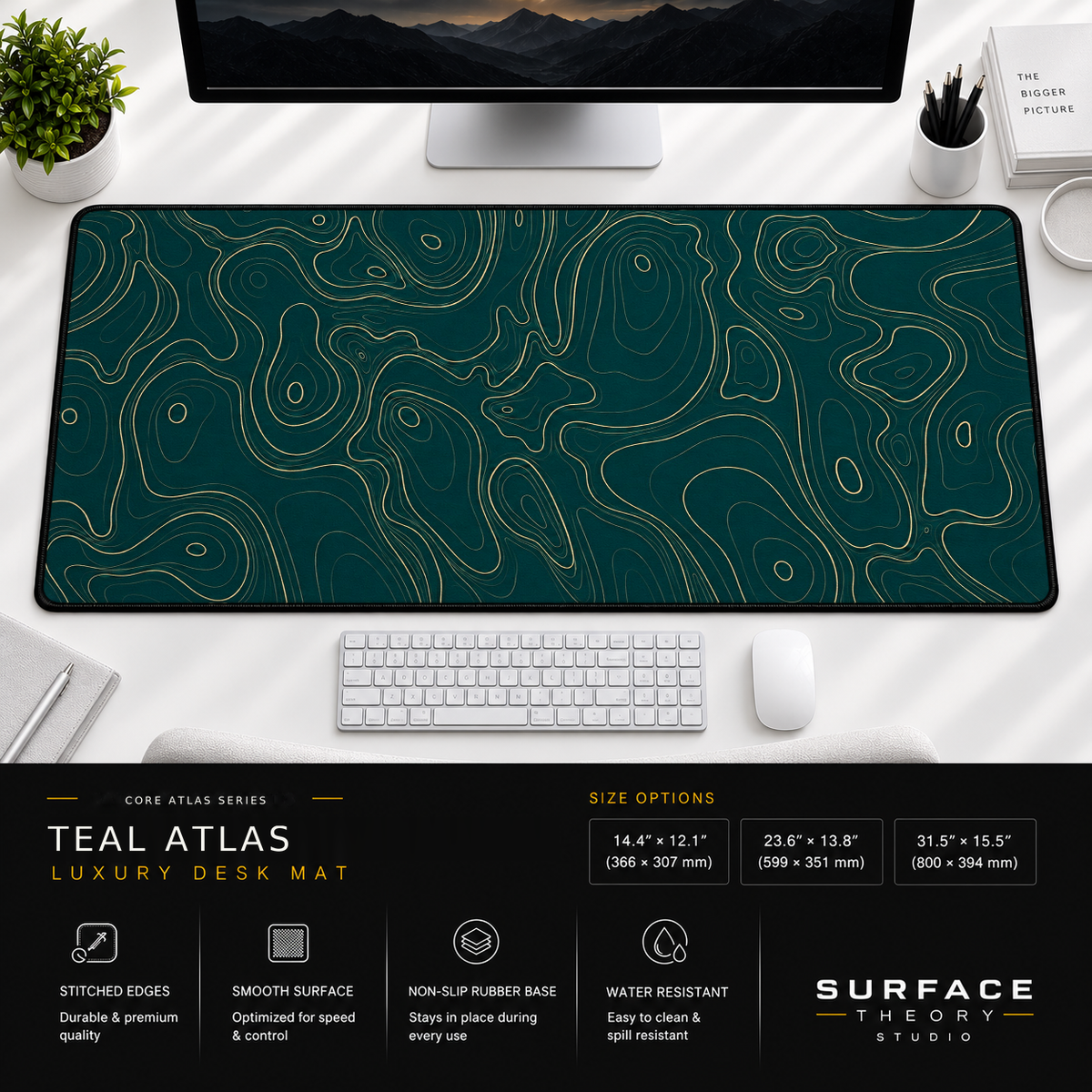 Teal Atlas desk mat beneath a monitor on a bright desk with a white keyboard and mouse.
