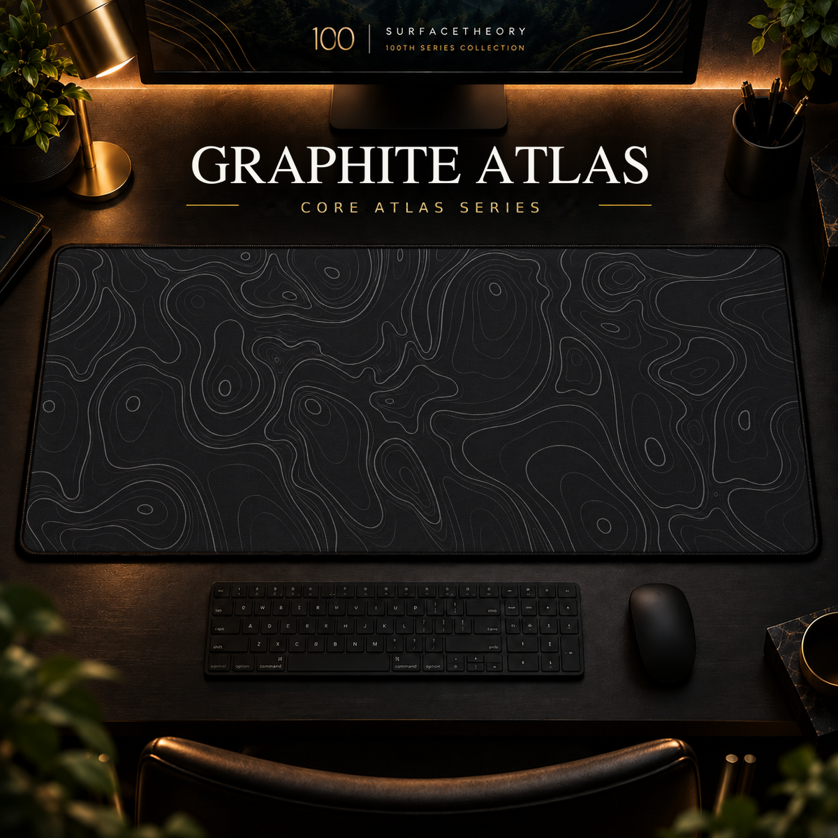 Graphite Atlas desk mat with fine topographic-inspired contours across the full surface in a warm, dark workspace.
