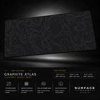 Graphite Atlas desk mat floating against a dark studio background.