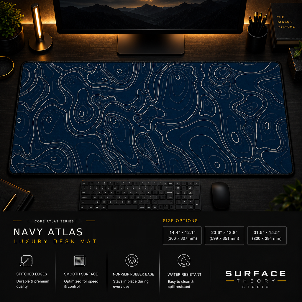 Navy Atlas desk mat in a dark workstation with warm monitor lighting.