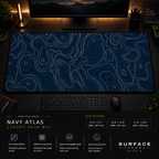 Navy Atlas desk mat in a dark workstation with warm monitor lighting.