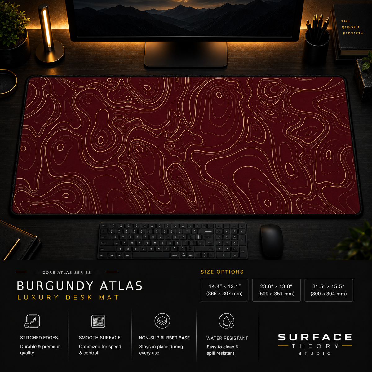 Burgundy Atlas desk mat in a dark workstation with warm monitor lighting.