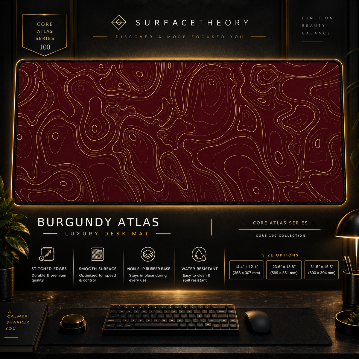 Burgundy Atlas desk mat in a gold-toned showcase frame above a keyboard.