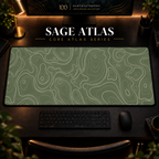 Sage Atlas desk mat with fine topographic-inspired contours across the full surface in a warm, dark workspace.