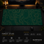 Forest Atlas desk mat in a dark workstation with warm monitor lighting.