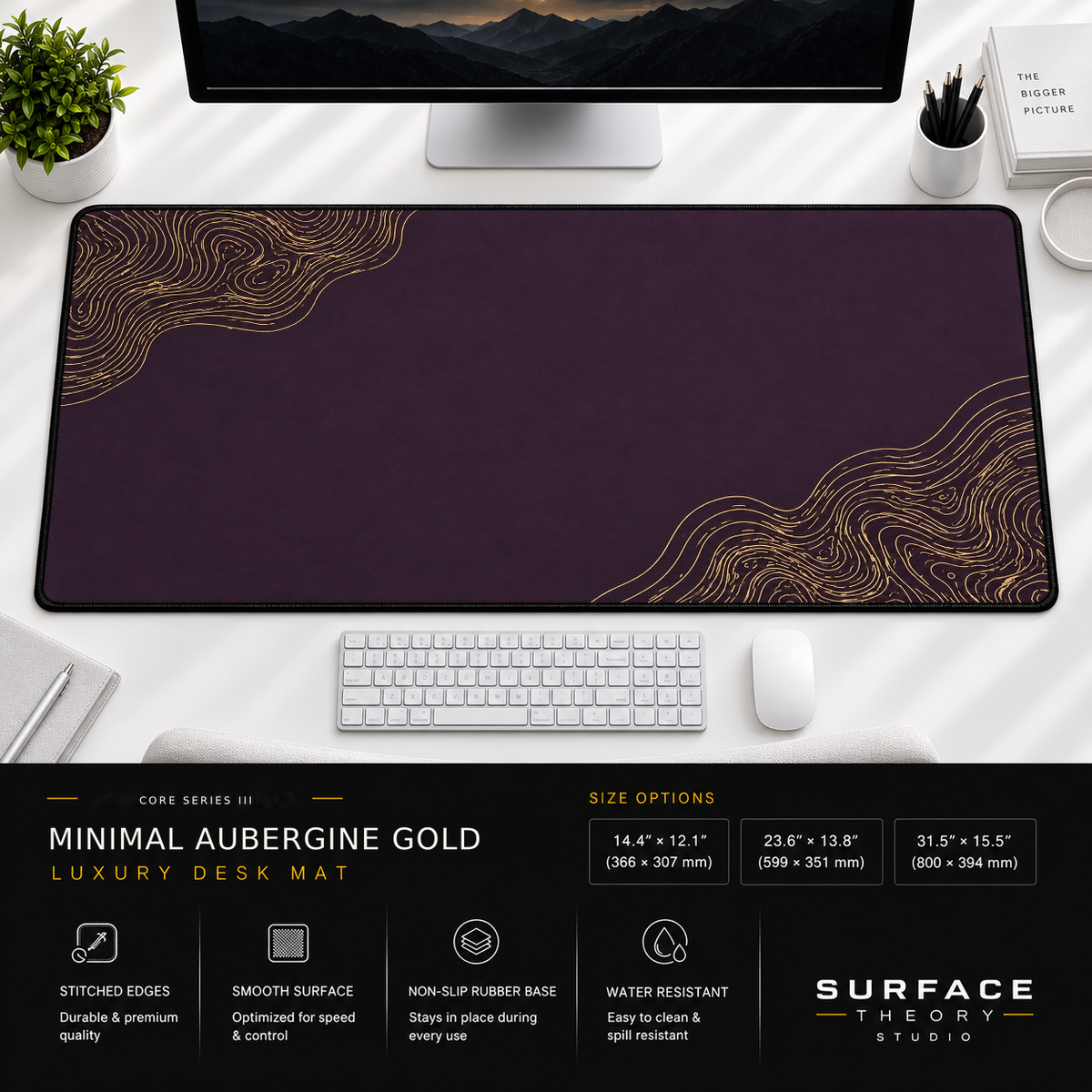 Minimal Aubergine Gold desk mat beneath a monitor on a bright desk with a white keyboard and mouse.