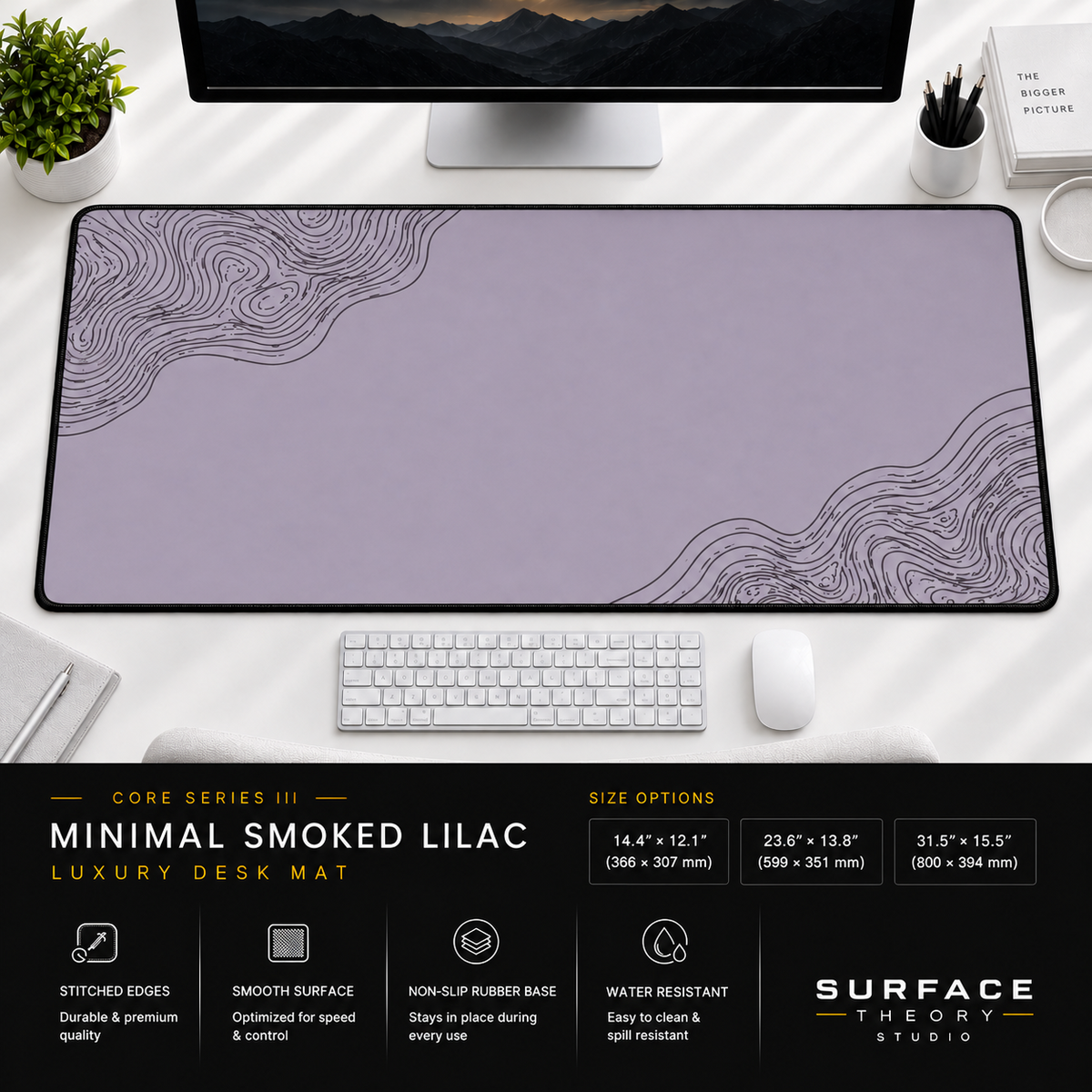 Minimal Smoked Lilac desk mat beneath a monitor on a bright desk with a white keyboard and mouse.