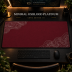 Minimal Oxblood Platinum desk mat with fine contours in opposing corners in a warm, dark workspace.