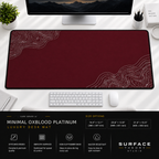 Minimal Oxblood Platinum desk mat beneath a monitor on a bright desk with a white keyboard and mouse.