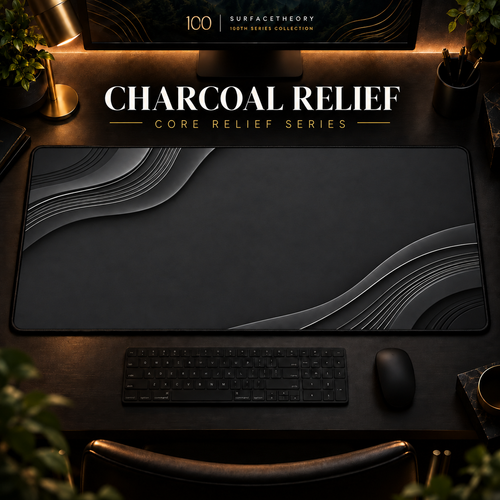 Charcoal Relief desk mat in a warm, dark workspace.