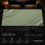 Sage Relief desk mat in a dark workstation with warm monitor lighting.