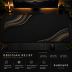 Obsidian Relief desk mat in a dark workstation with warm monitor lighting.