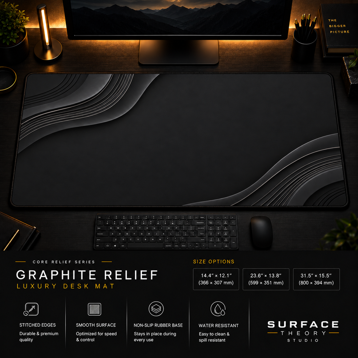 Graphite Relief desk mat in a dark workstation with warm monitor lighting.