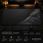 Charcoal Facet desk mat in a dark workstation with warm monitor lighting.